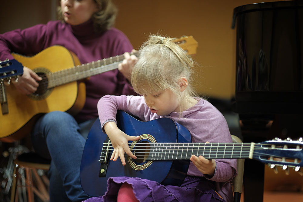 Kleines Mädchen mit kleiner Gitarre