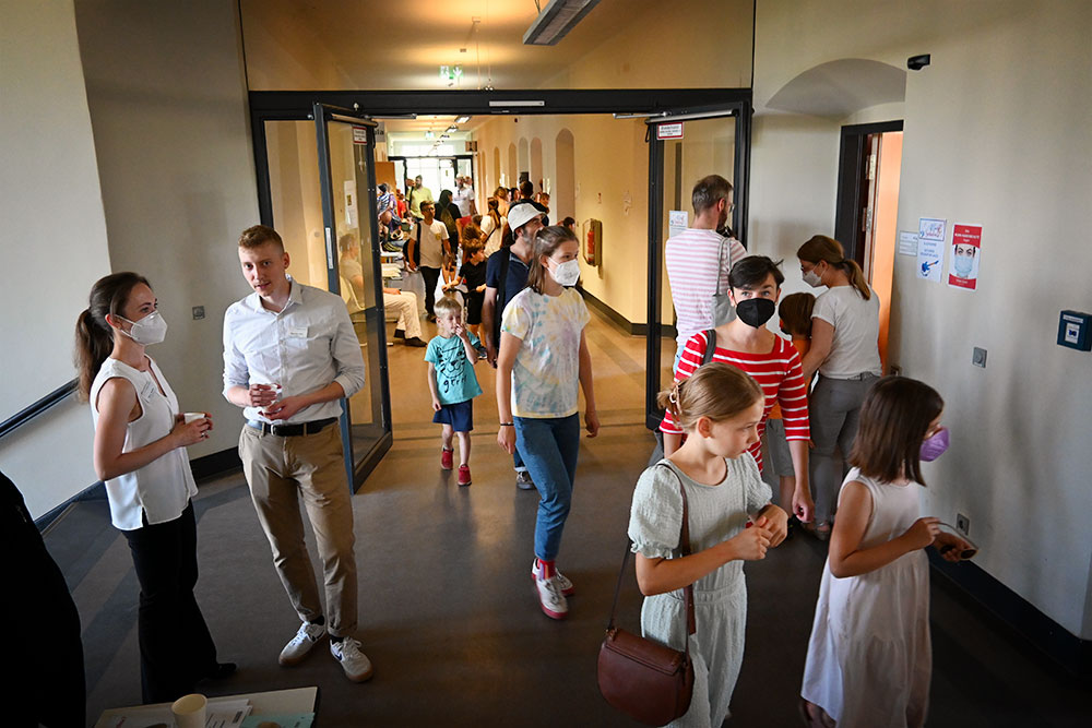 Viele Kinder und Erwachsene laufen auf dem Gang der Musikschule von Tür zu Tür.
