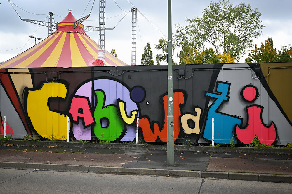 Der Zaun um den Zirkusplatz ist mit dem Graffiti-Schriftzug CABUWAZI verziert.