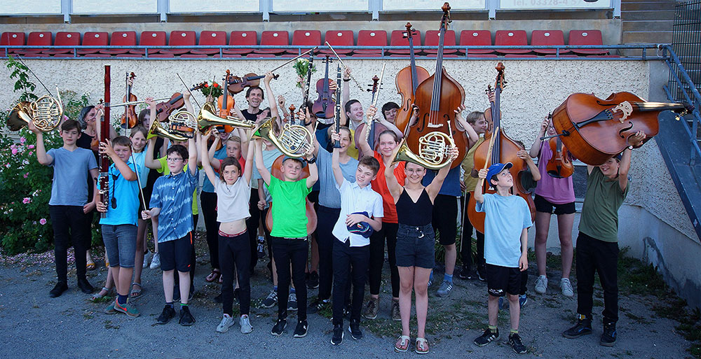 Die Kinder des Jugendorchesters mit hochgehaltenen Instrumenten